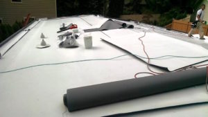 A flat roof with a technician working in the background